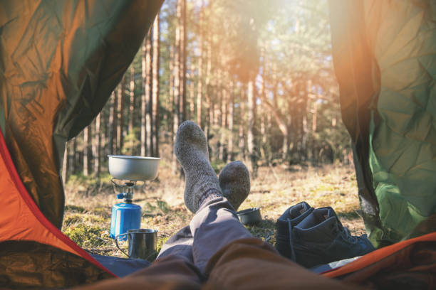 wanderlust outdoor camping - traveler feet out of the tent
