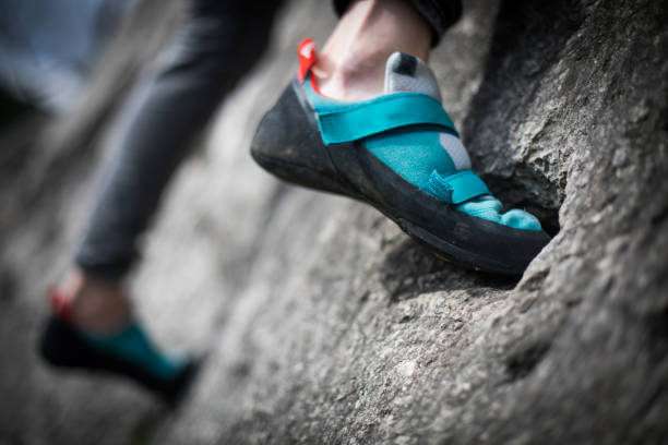 Close up shot o a person climbing while wearing rock climbing shoes.